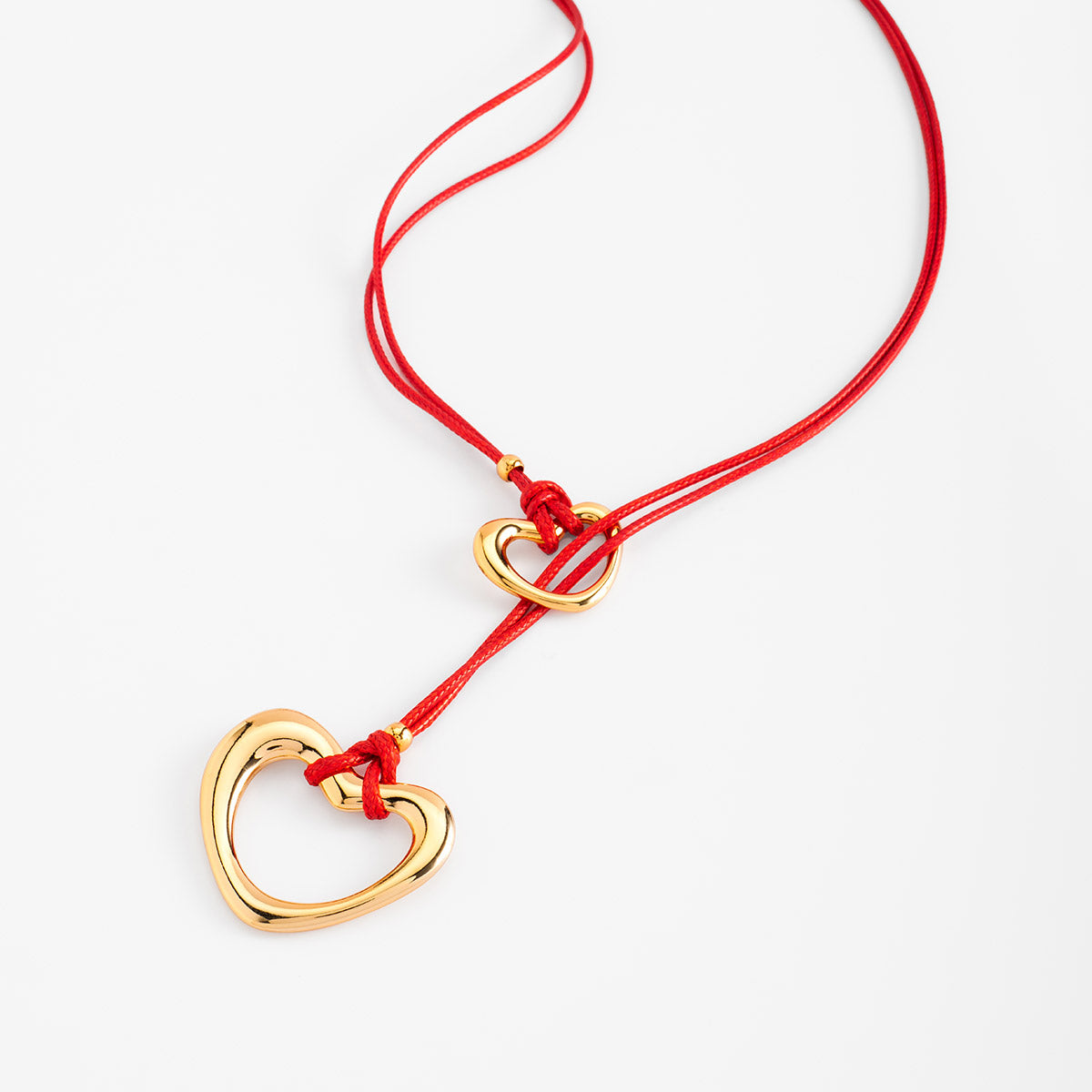 Collar en baño de oro con dijes de corazón y cordón rojo