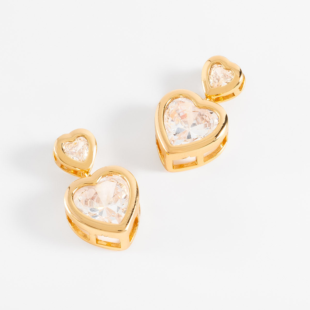 Aretes en baño de oro doble corazón con piedras en tono cristal