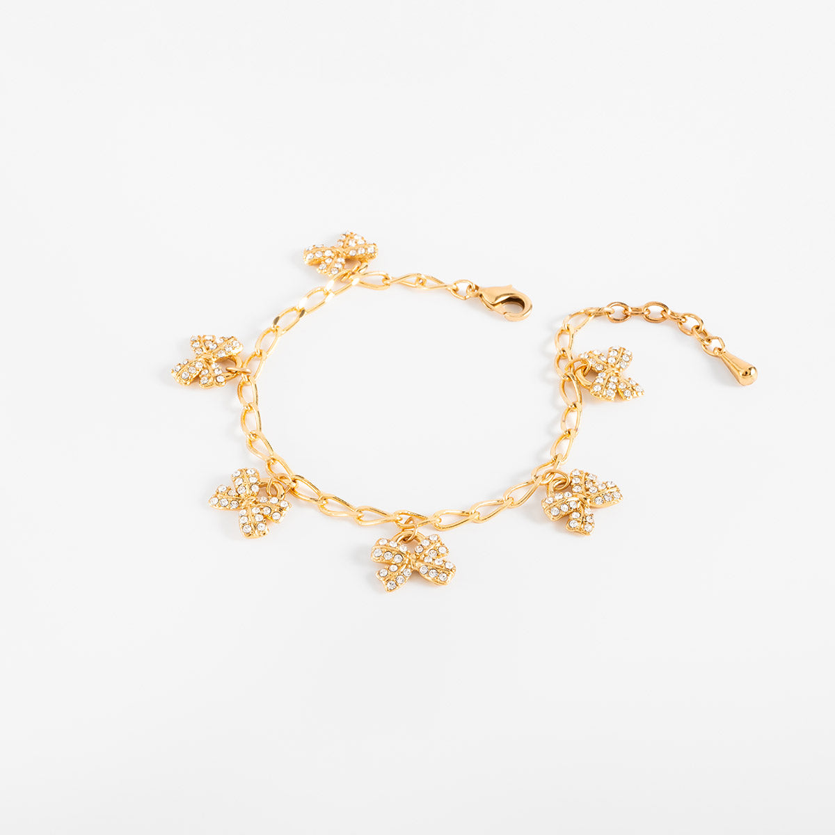 Pulsera en baño de oro dijes moño piedras toque brillante