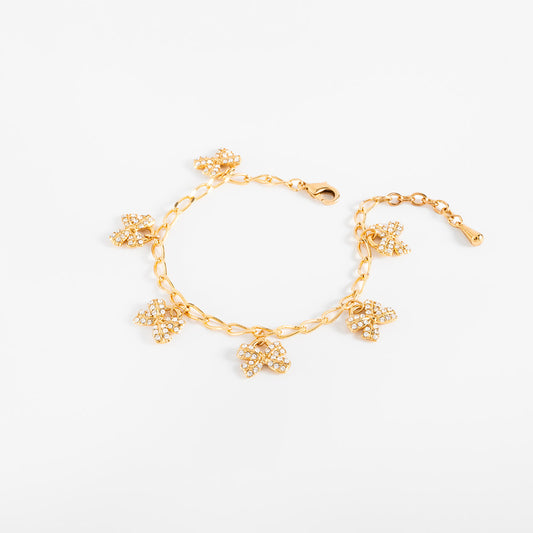 Pulsera en baño de oro dijes moño piedras toque brillante